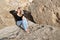 Dreamily young woman relaxing on big stones.