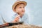 Dreaming boy with book lies on hay stack