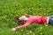 Dreaming girl lying among dandelions