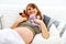 Dreaming pregnant woman lying on sofa with toys