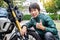 Dreams come true, Cheerful Handsome rider biker man in green leather jacket smiling to the camera joyfully showing thumbs up