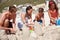 Dreams made of sand and sun. Shot of a happy family building sandcastles together at the beach.