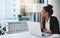 Dreams will get you far. a young businesswoman using a laptop at her desk in a modern office and looking thoughtful.