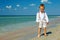Dreamy baby boy stands in surf on sea beach