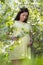 dreamy beautiful pregnant woman walking in blooming spring garden