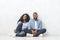 Dreamy black couple sitting on floor, planning interior