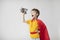 Dreamy boy in a red cape plays with an airplane toy