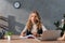 Dreamy businesswoman sitting at table and holding pen