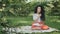 Dreamy curly girl writes poems in park on plaid