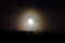 Dreamy full moon night sky over spruce tree forest and mountain