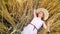 Dreamy girl lying on wheat field in summer