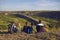 Dreamy group of young hikers sitting on the edge of the mountain and looking into the distance.