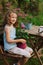 dreamy happy child girl relaxing in summer evening garden with geranium flower in pot