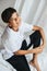 Dreamy indian boy sitting on a table, looking at the camera