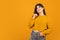 Dreamy look. Cropped portrait of young beautiful expressive girl isolated on orange studio background