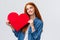 Dreamy, lovely caucasian redhead female dreaming to give valentines day card to lover, looking up thoughtful, imaging