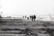 Dreamy Nostalgia: People Walking on Rocky Shoreline in Black and White