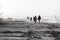 Dreamy Nostalgia: People Walking on Rocky Shoreline in Black and White