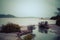 Dreamy photo of rainy day at lake Rotorua. Coastline shrubbery over rocks