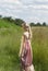 Dreamy portrait of bohemian blonde girl in field of grass