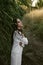 Dreamy portrait of a young woman wearing white, standing in the field of reeds during golden hour.