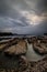 Dreamy seascape for background. Beach with rocks and stones. Low tide. Blurred foggy water. Cloudy sky. Slow shutter speed. Soft