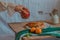 Dreamy shot of dainty hand holding a pomegranate over a table with tangerines and waffle for breakfast