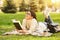 Dreamy student girl reading book, resting in park