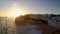 Dreamy sunset on cliffed coastlines in Carvoeiro, Portugal. With lots of housing in the distance.