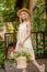 Dreamy tween girl with wildflower in basket standing on doorstep of country house