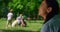 Dreamy woman sitting in front of playing family closeup. Active leisure concept.