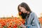 Dreamy woman smelling a poppy flower in meadow.