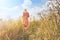 Dreamy woman walking in nature towards the sun