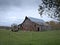 Dreary Abandoned Dilapidated Farm Barn with cloudy skies