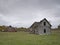 Dreary Abandoned Dilapidated Farm House and Barn with cloudy skies