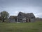 Dreary Abandoned Dilapidated Farm House with cloudy skies