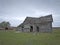 Dreary Abandoned Dilapidated Farm House with cloudy skies