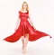 Dress rent service, fashion industry. Woman wears elegant evening red dress, white background. Lady rented fashionable