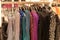 Dress-up, festive women `s clothes with glitter and payets on hangers in the store. Season of sale, black Friday, preparation for