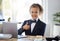 Dressed for success. an adorable little girl dressed as a businessperson sitting alone in an office and showing a thumbs