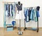 Dressing closet with blue clothes arranged on hangers. Cute summer outfit on a mannequin.