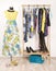 Dressing closet with colorful clothes arranged on hangers and a