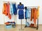 Dressing closet with complementary colors blue and orange clothes.