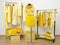 Dressing closet with yellow clothes arranged on hangers and a wi