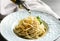 Dressing delicious basil pesto pasta with olive oil