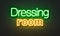 Dressing room neon sign on brick wall background.