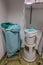 a dressing room in a surgical department in a hospital, the used green surgical clothing is discarded