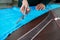 Dressmaker cutting blue fabric in tailor studio, atelier shop