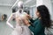 Dressmaker fixing white lace wedding dress on a mannequin in tailor studio