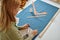 Dressmaker measures cloth on the table in workshop